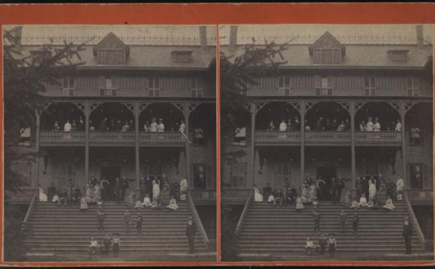 Residents crowd the steps and balcony of a boarding house in New York, circa 1860.