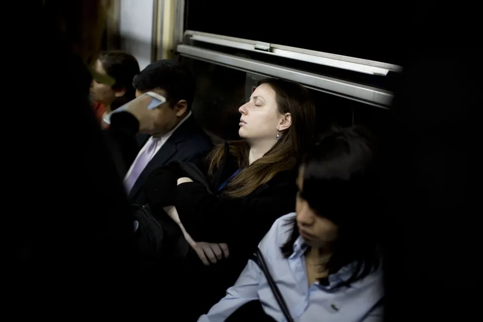 A young woman sleeps on the subway as she heads downtown during rush hour in Buenos Aires, Argentina.
