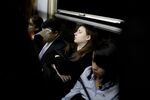 A young woman sleeps on the subway as she heads downtown during rush hour in Buenos Aires, Argentina.