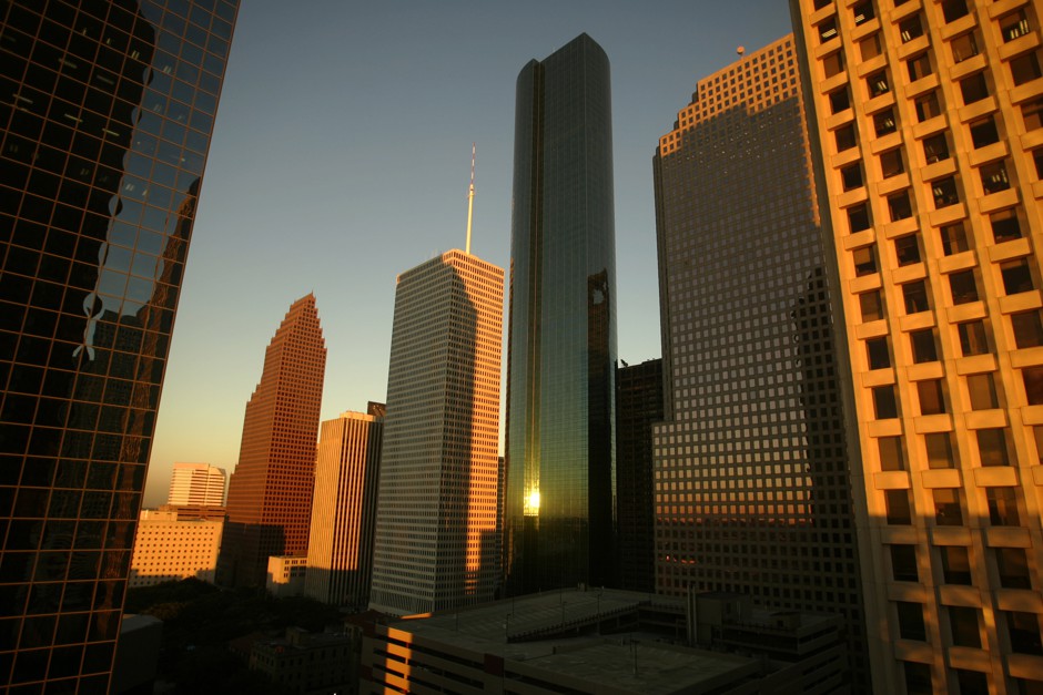 Buildings in downtown Houston reflect the light of the setting sun.