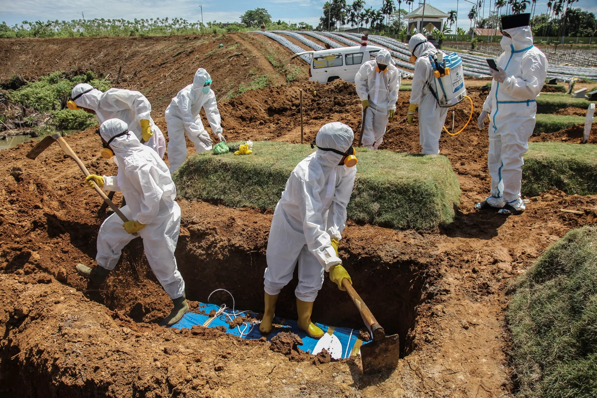 Funeral workers burying Covid-19 victims at a cemetery in Medan, Indonesia, on July 19.