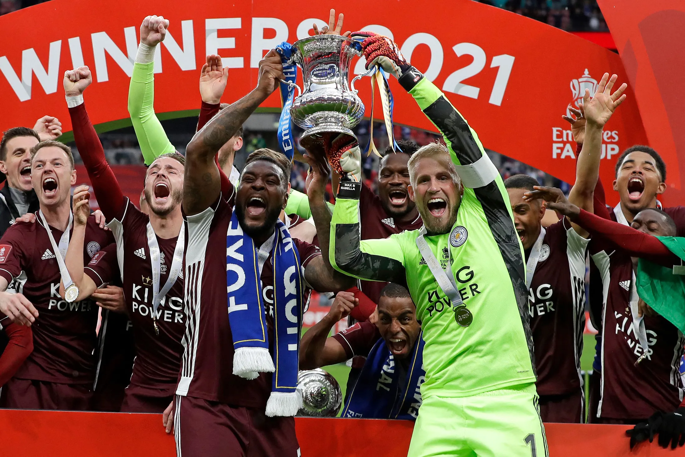 Leicester City’s Wes Morgan and Kasper Schmeichel hold up the winner’s trophy as the team celebrates victory in the English FA Cup final on May 15.