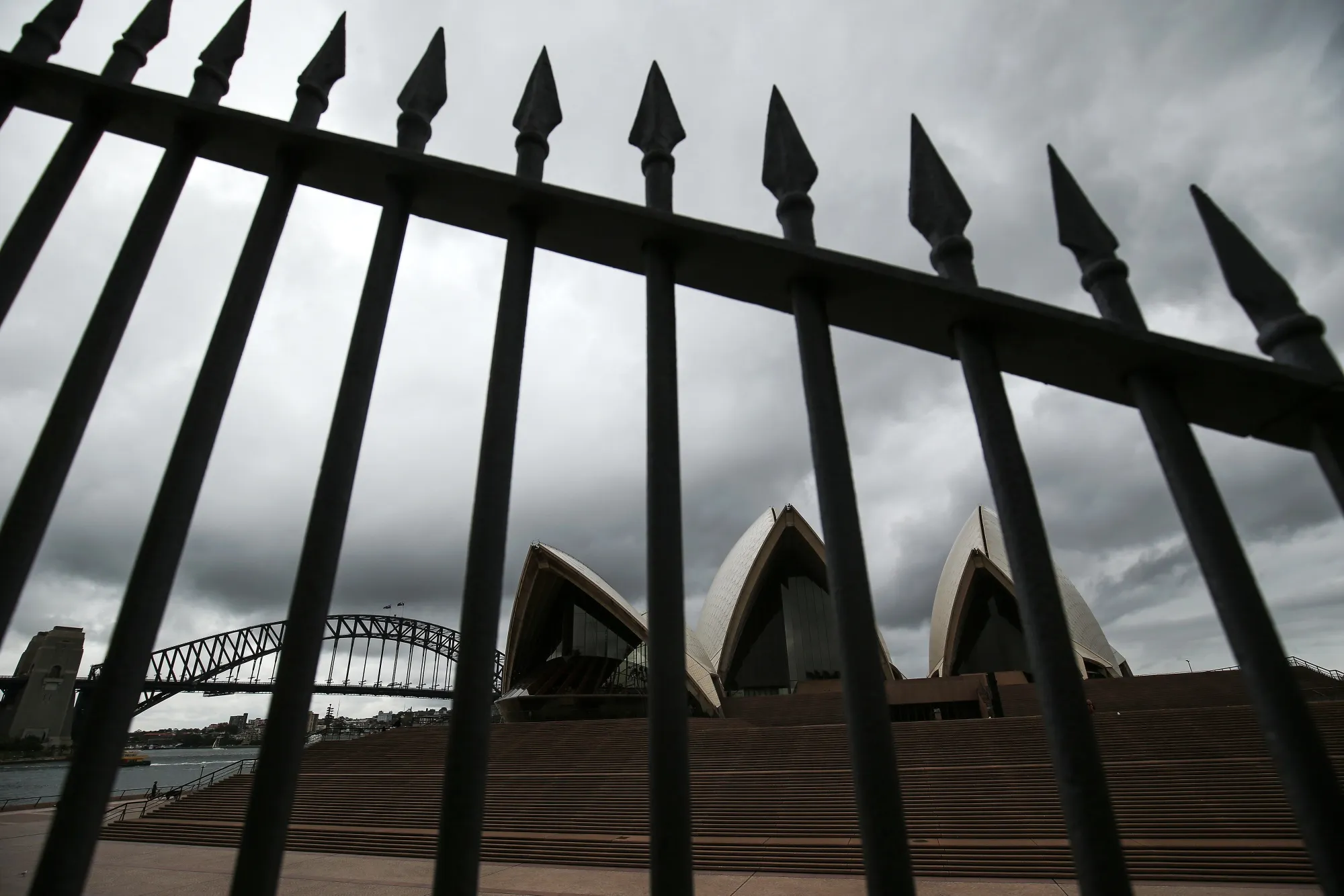 The Sydney Harbour Bridge stands across from the closed Sydney Opera House in Sydney.
