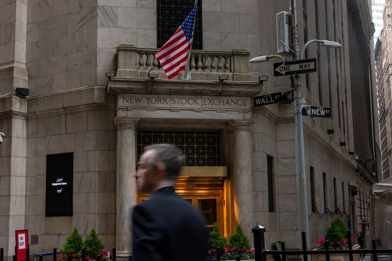 Pedestrians walk along Wall Street near the New York Stock Exchange (NYSE) in New York, US