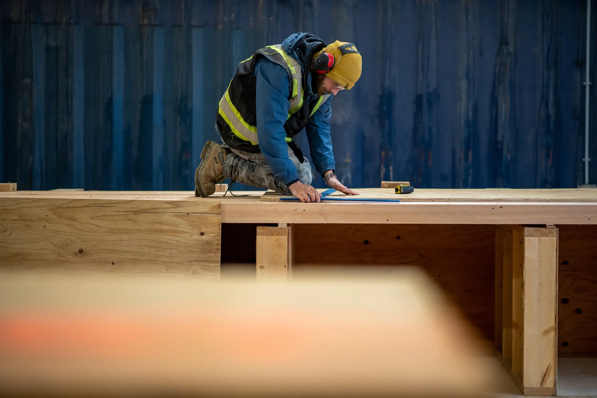 A worker measures mass timber ceiling panels in Bamberton, British Columbia.