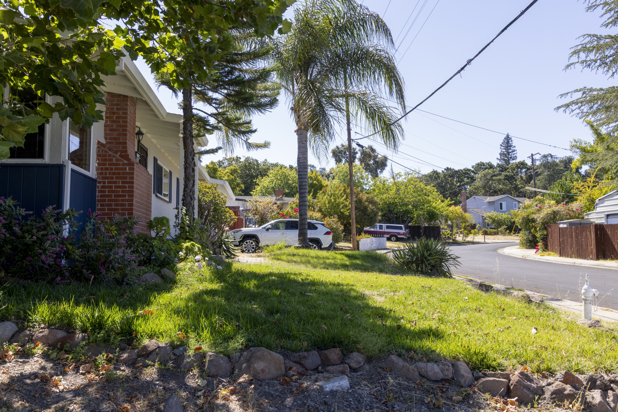 A photo of a house on a suburban road surrounded by greenery.