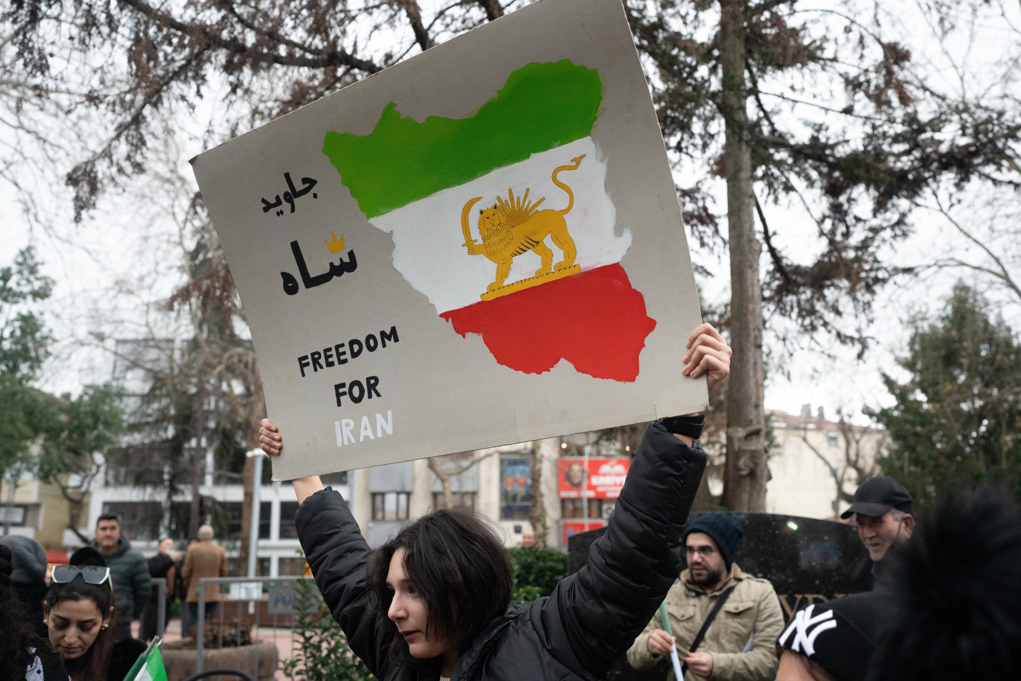 A protester holds a 'Freedom for Iran' sign with the Iranian Lion and Sun flag at a rally in support of Iran's anti-government protests, in Yalova, Turkey, on Friday, Jan. 16, 2026. The violent crackdown of weeks on protests in Iran has drawn international condemnation. Photographer: Emre Caylak/Bloomberg