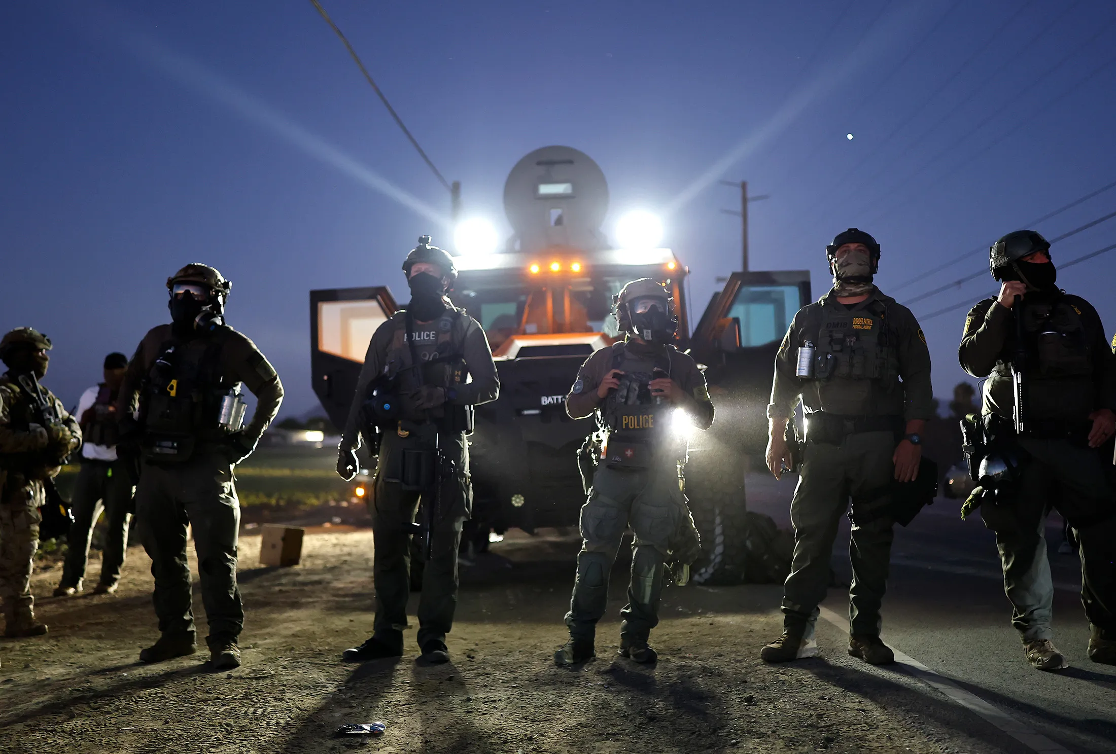 Federal agents block people protesting an ICE immigration raid at a nearby licensed cannabis farm in Camarillo, California, on July 10.