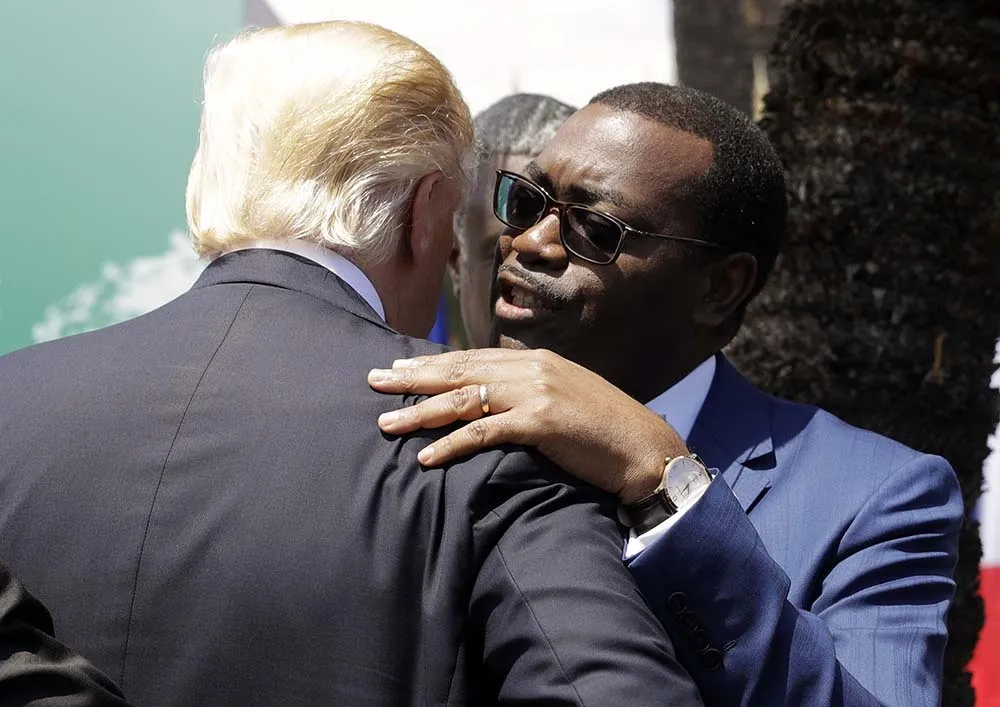 Akinwumi Adesina hugs&nbsp;President Donald Trump at the G7 in Taormina, Italy, in 2017.&nbsp;