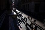 Pedestrians walk along Wall Street near the New York Stock Exchange (NYSE) in New York.