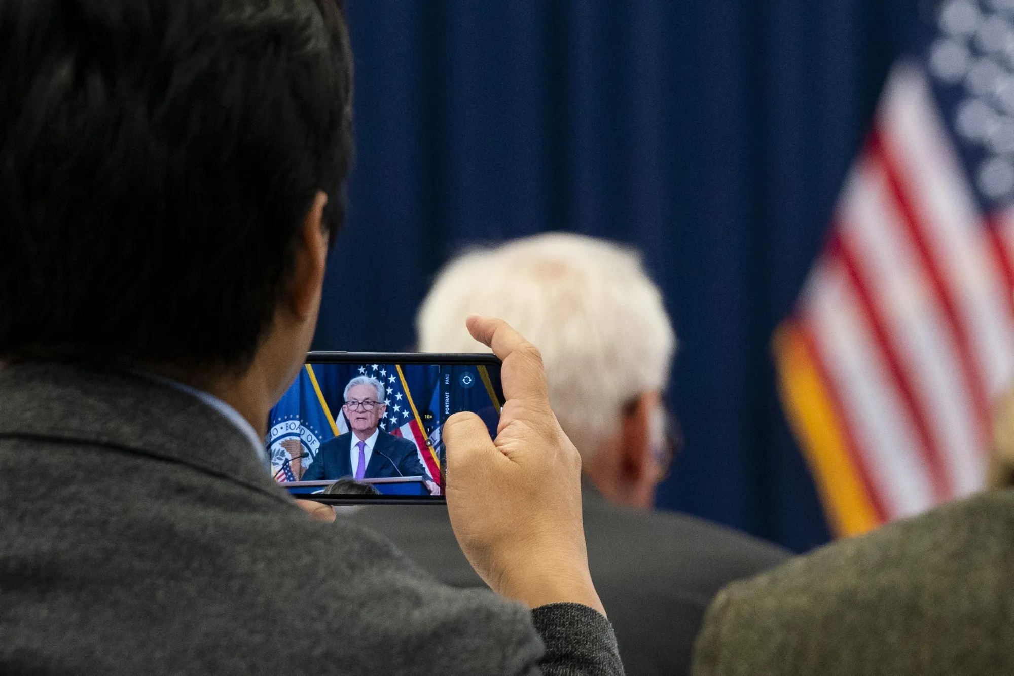 A journalist takes a photograph of Jerome Powell, chairman of the US Federal Reserve, during a news conference following a Federal Open Market Committee (FOMC) meeting in Washington, DC, US, on Wednesday, Sept. 20, 2023. The Federal Reserve left its benchmark interest rate unchanged while signaling borrowing costs will likely stay higher for longer after one more hike this year.