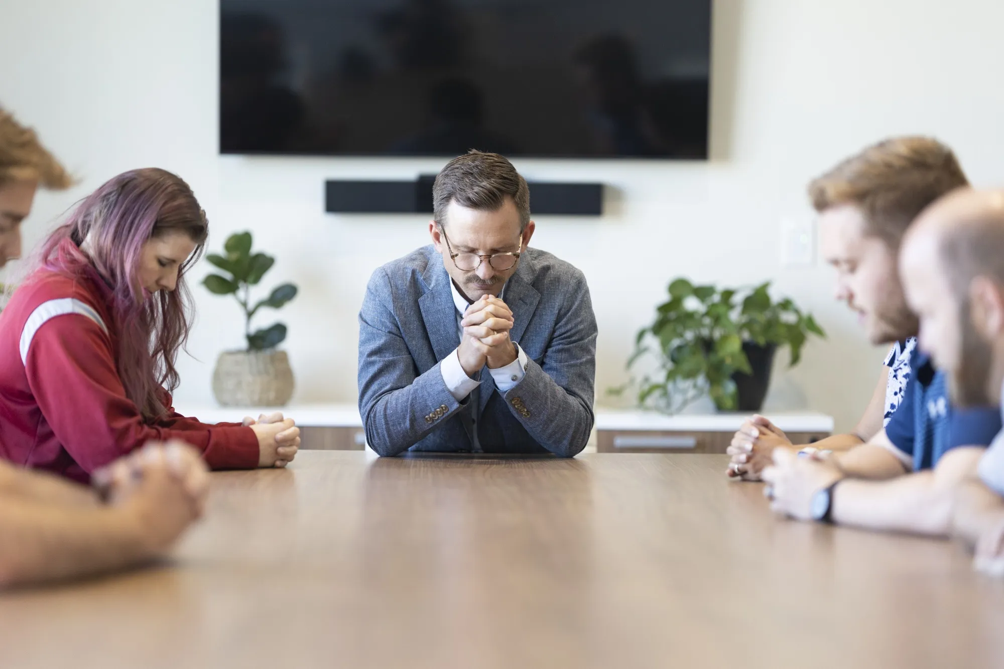 Robert Netzly leads employees in prayer before a meeting at Inspire Investing in Meridian, Idaho.