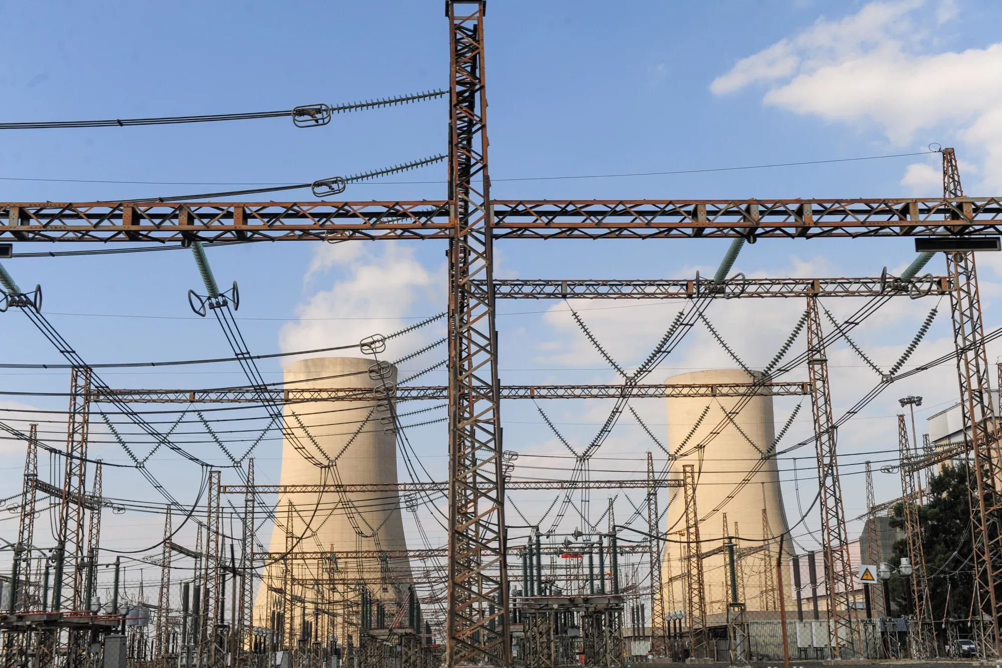 Cooling towers beyond an electricity substation at the Eskom Holdings Lethabo coal-fired power station in Vereeniging, South Africa.