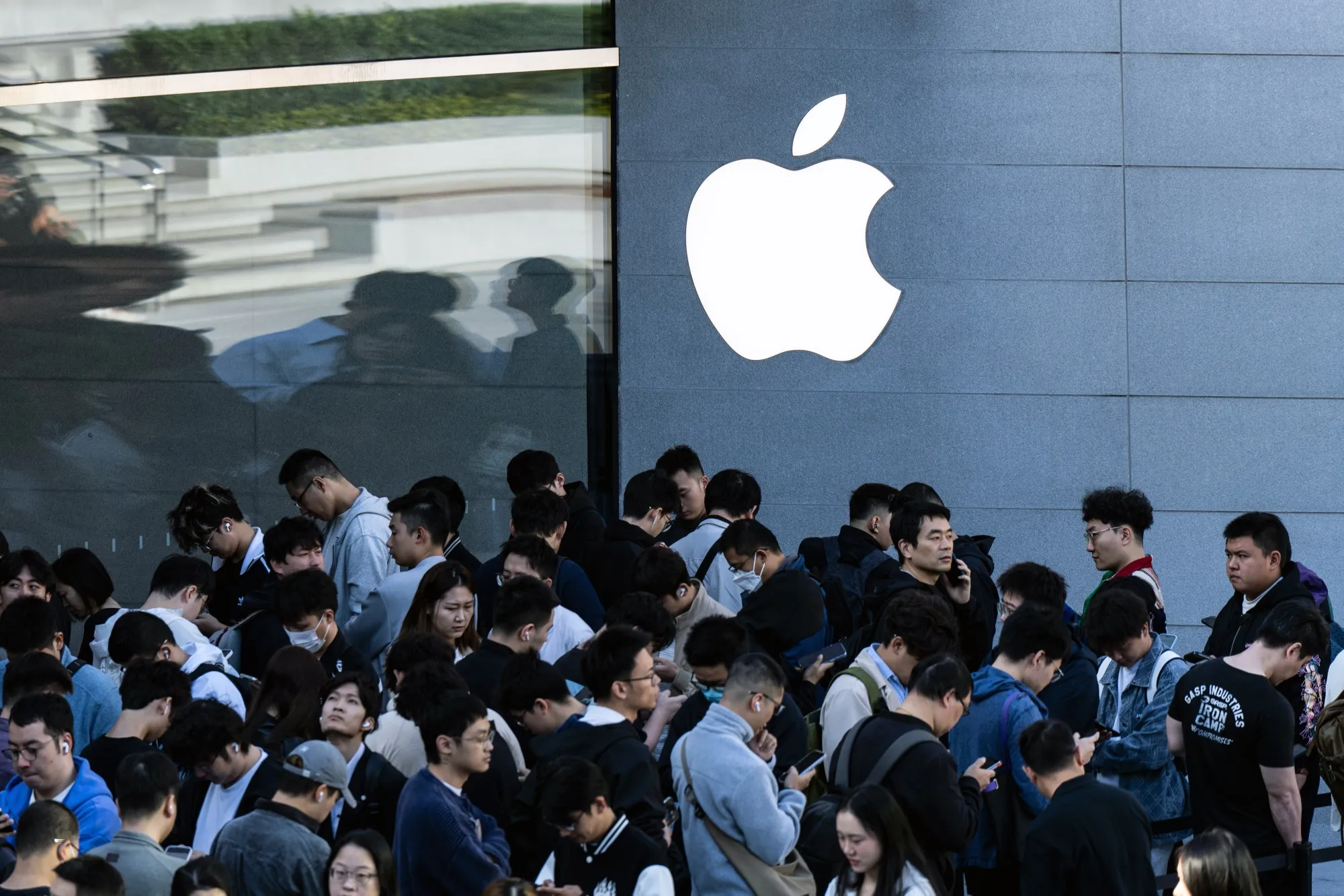 Customers wait in line at Apple Inc.'s Jing'an store in Shanghai, on Oct. 23