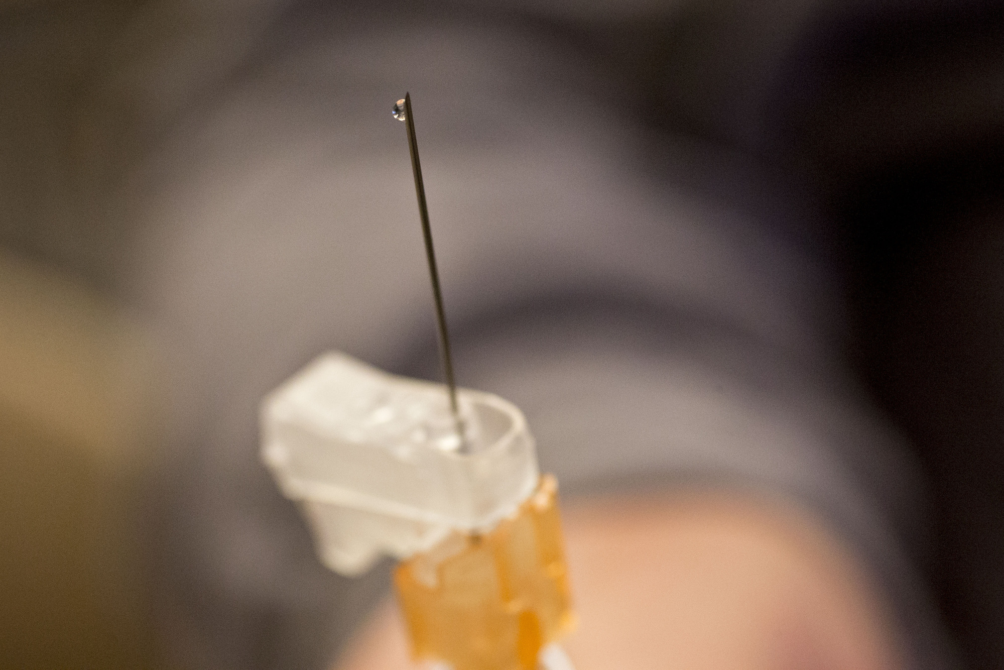 Liquid vaccine flows from a flu shot at a hospital.