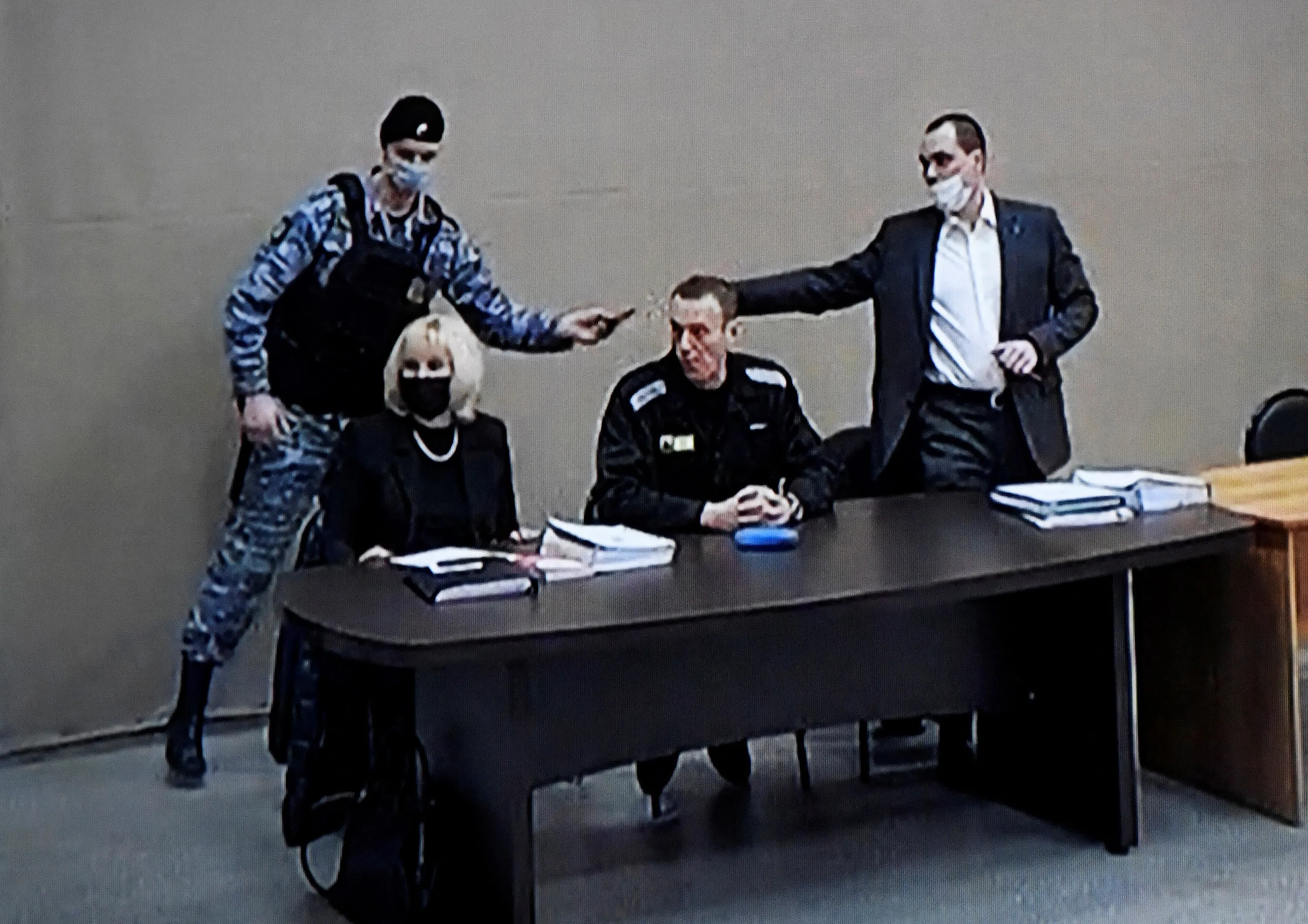 A photograph taken from a TV screen shows Alexey Navalny, center, during the court hearing in Pokrov, Russai, on Feb. 15.&nbsp;