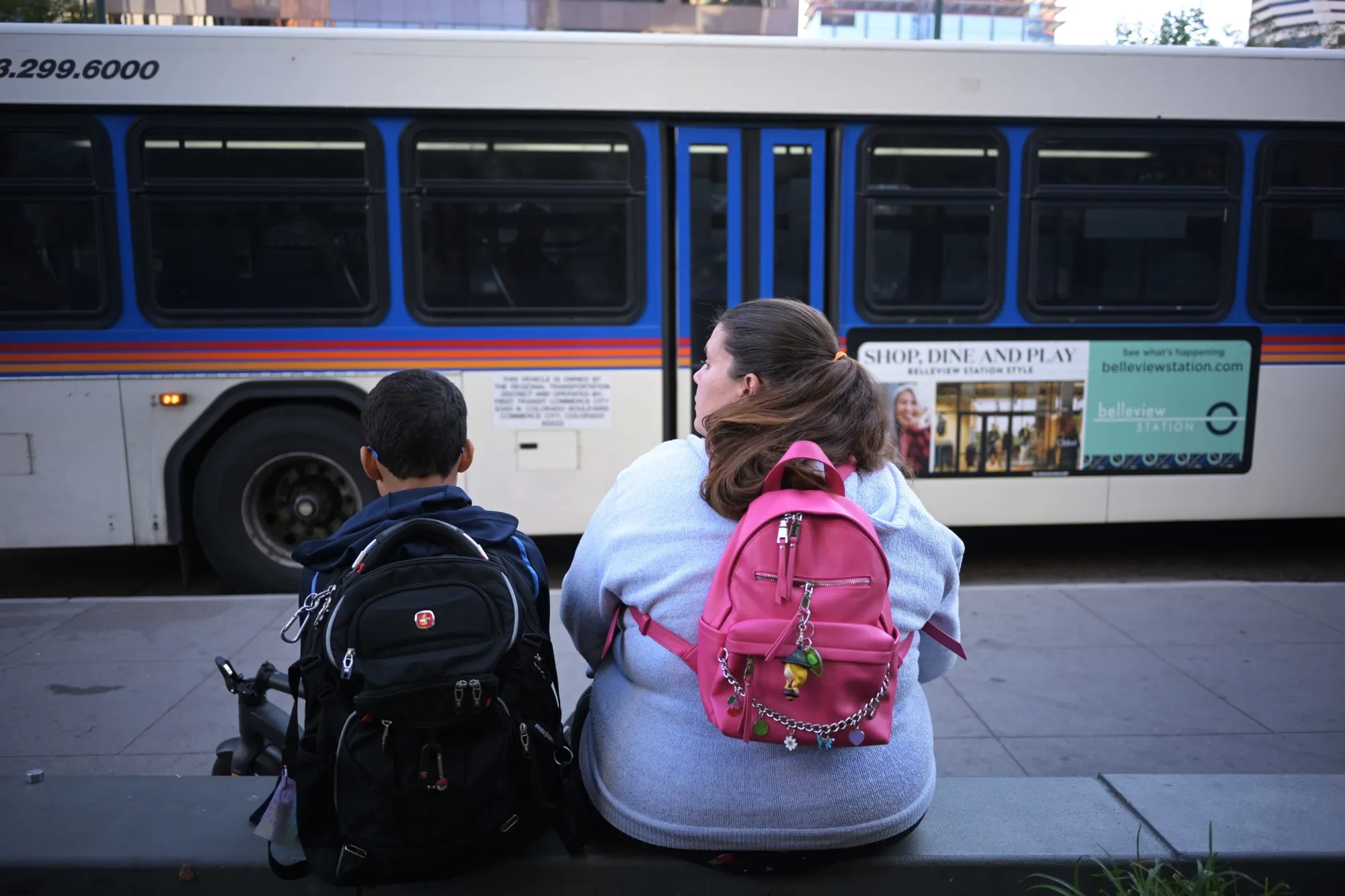 A family waits for a bus ride to school in Denver in September 2023.&nbsp;