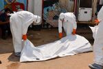 Liberian Red Cross health workers wearing protective suits carry the body of a victim of the Ebola virus in Monrovia on Sept. 12