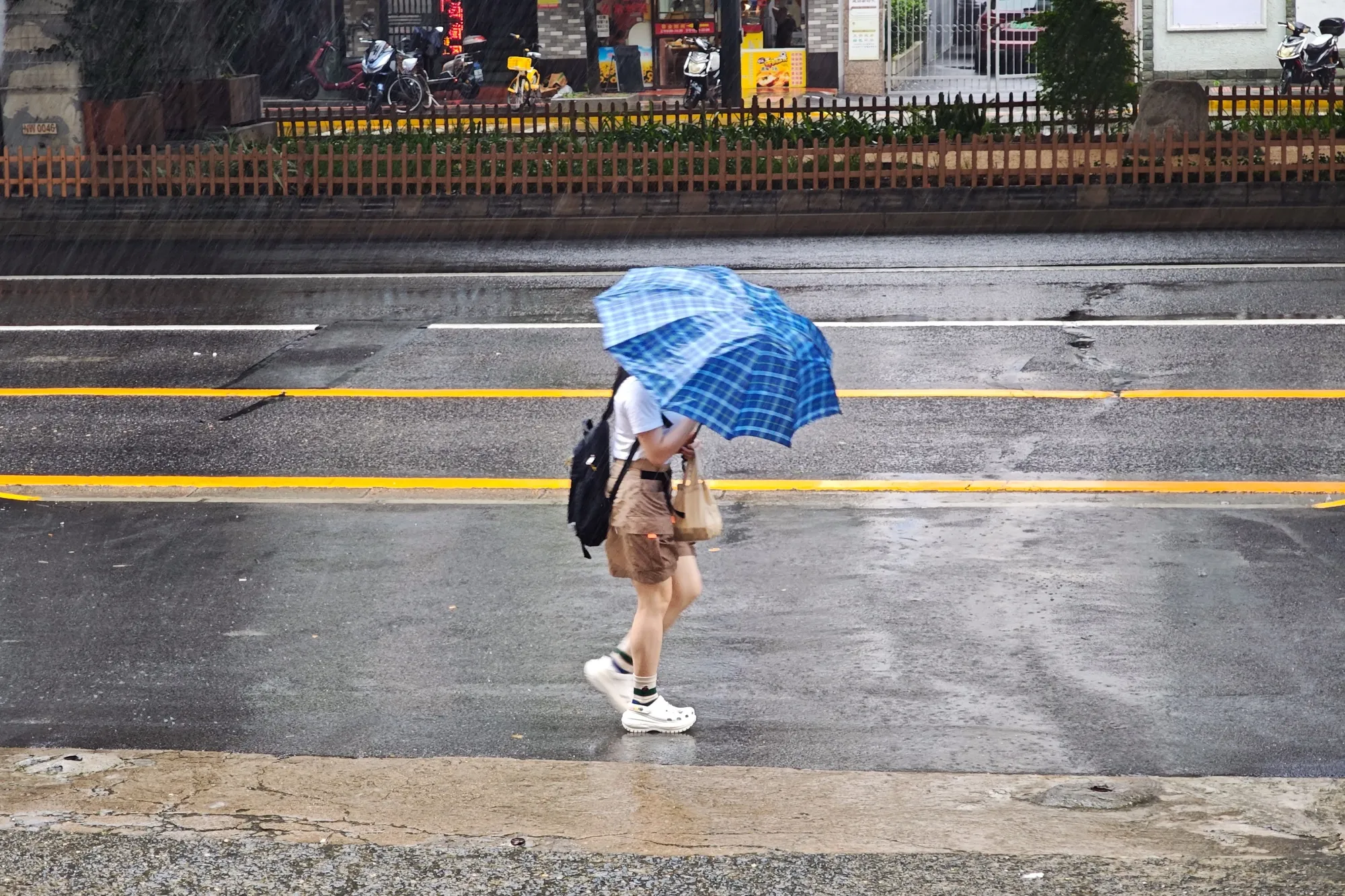 A pedestrian struggles with an umbrella&nbsp;in Shanghai on July 30.