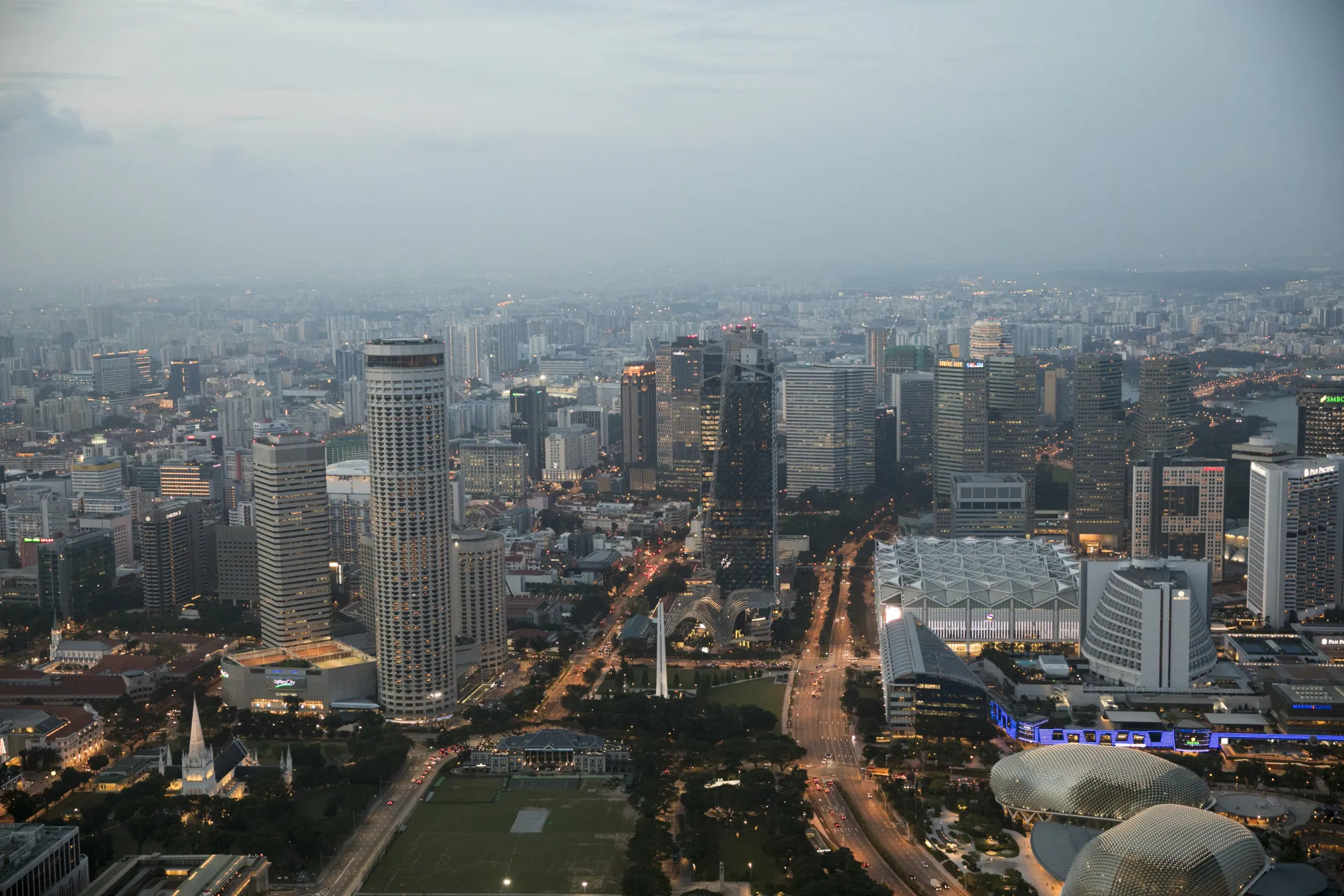 Commercial and residential buildings stand at dusk in Singapore