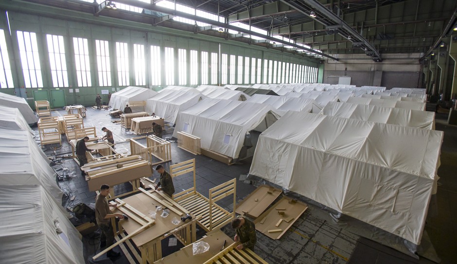 German soldiers set up tents and beds for migrants in a hangar of the former Tempelhof Airport in Berlin on October 25, 2015.