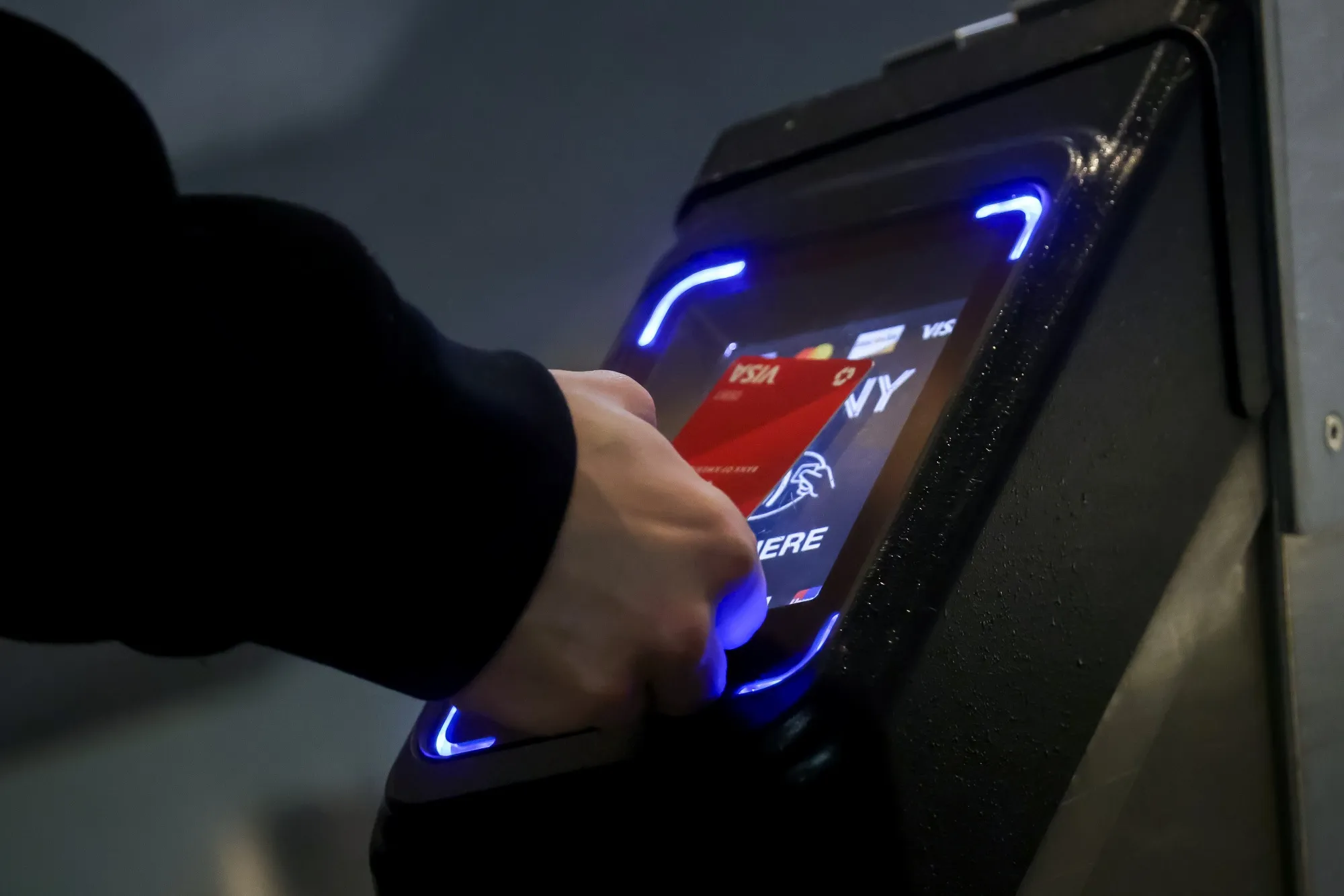 A commuter taps a credit card on a One Metro New York device at a subway station in New York.