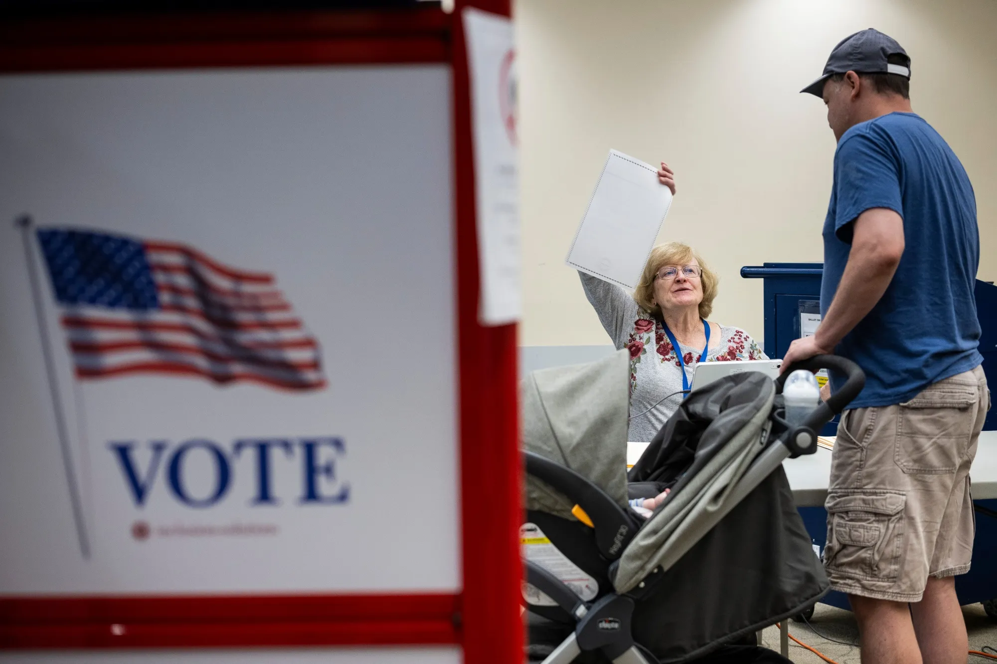 An election official checks in a voter on the last day of early voting at a polling location in Burke, Virginia.