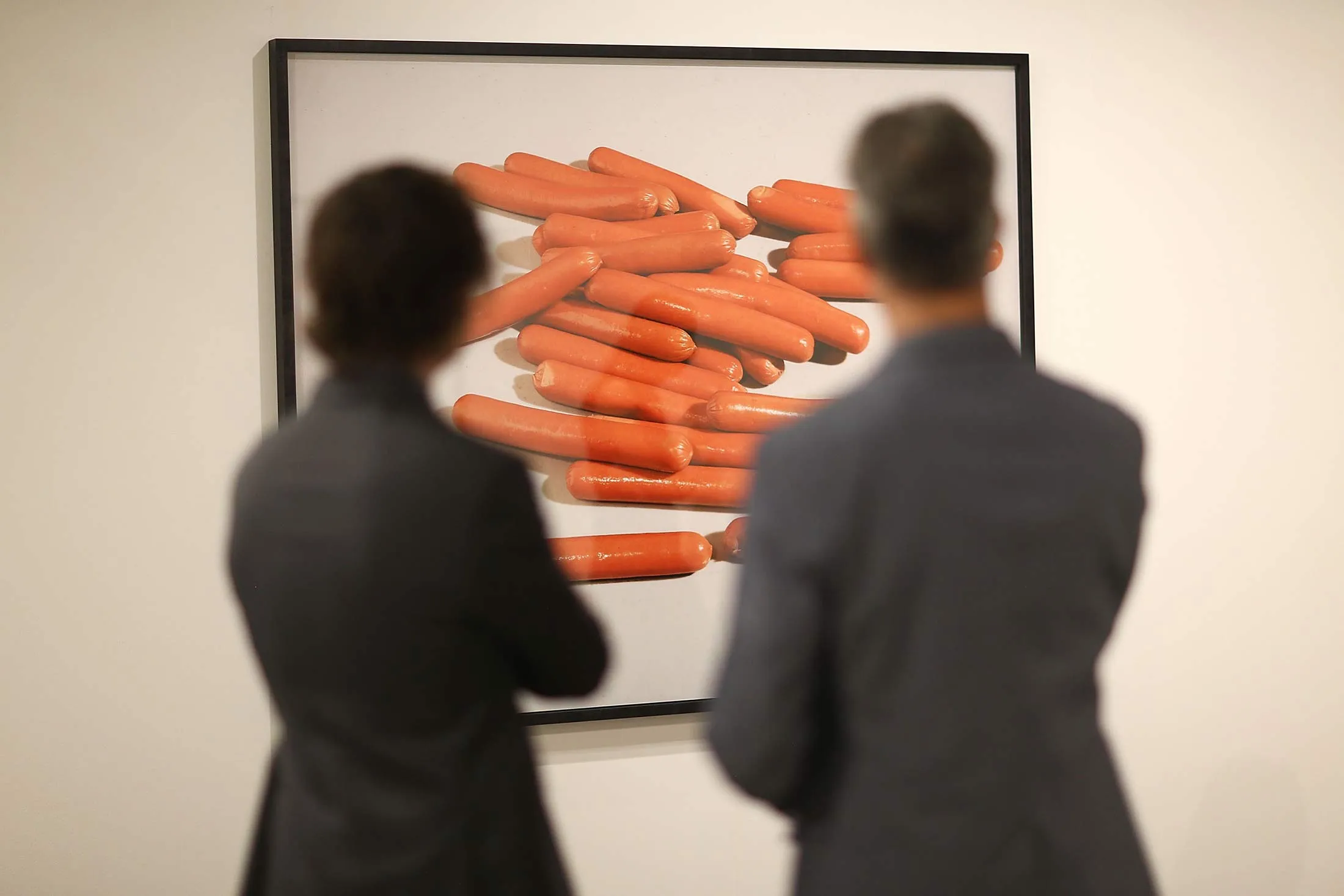 People look on at a piece by artist Lucas Blalock on display during the opening day of Art Basel on Dec. 2, 2015 in Miami Beach, Florida.
