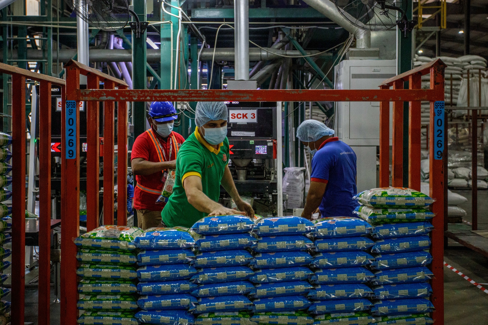 Thai workers prepare rice sacks to be sold at the Department of