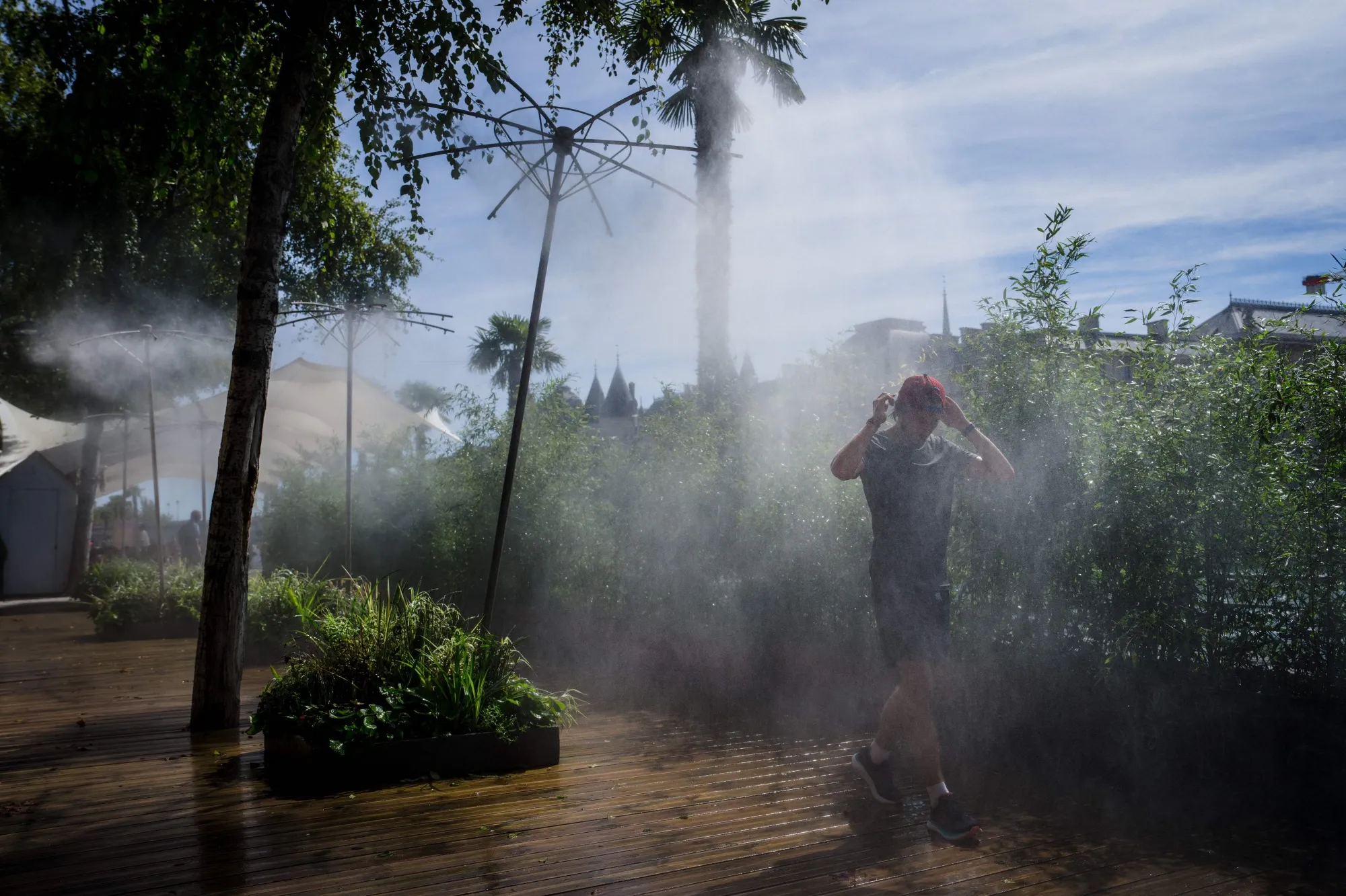 A man cools off under a water mister in central Paris in September.