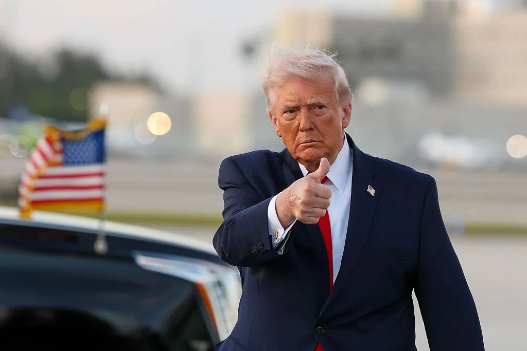 President Donald Trump waves to the media after walking off of Air Force One at Miami International Airport on April 11.
