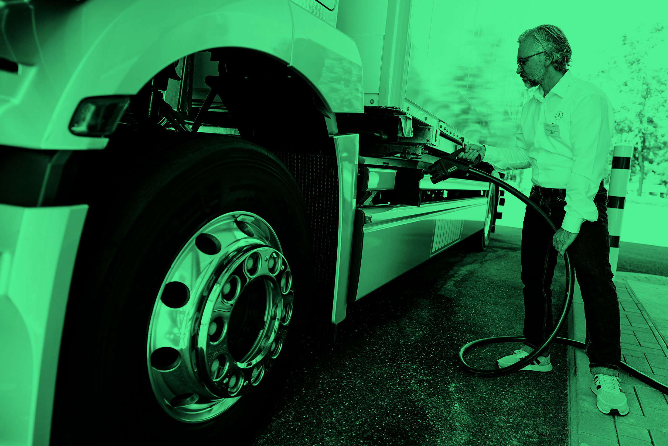 25 July 2022, Rhineland-Palatinate, Wörth am Rhein: An employee demonstrates how to charge a truck at the Mercedes-Benz Trucks KundenCenter during the opening of the new Netze BW and Daimler Truck demo charging park. At the new customer demo park, visitors will be able to test charging columns and charging concepts for electric trucks in real-life operation from August 1, 2022. 