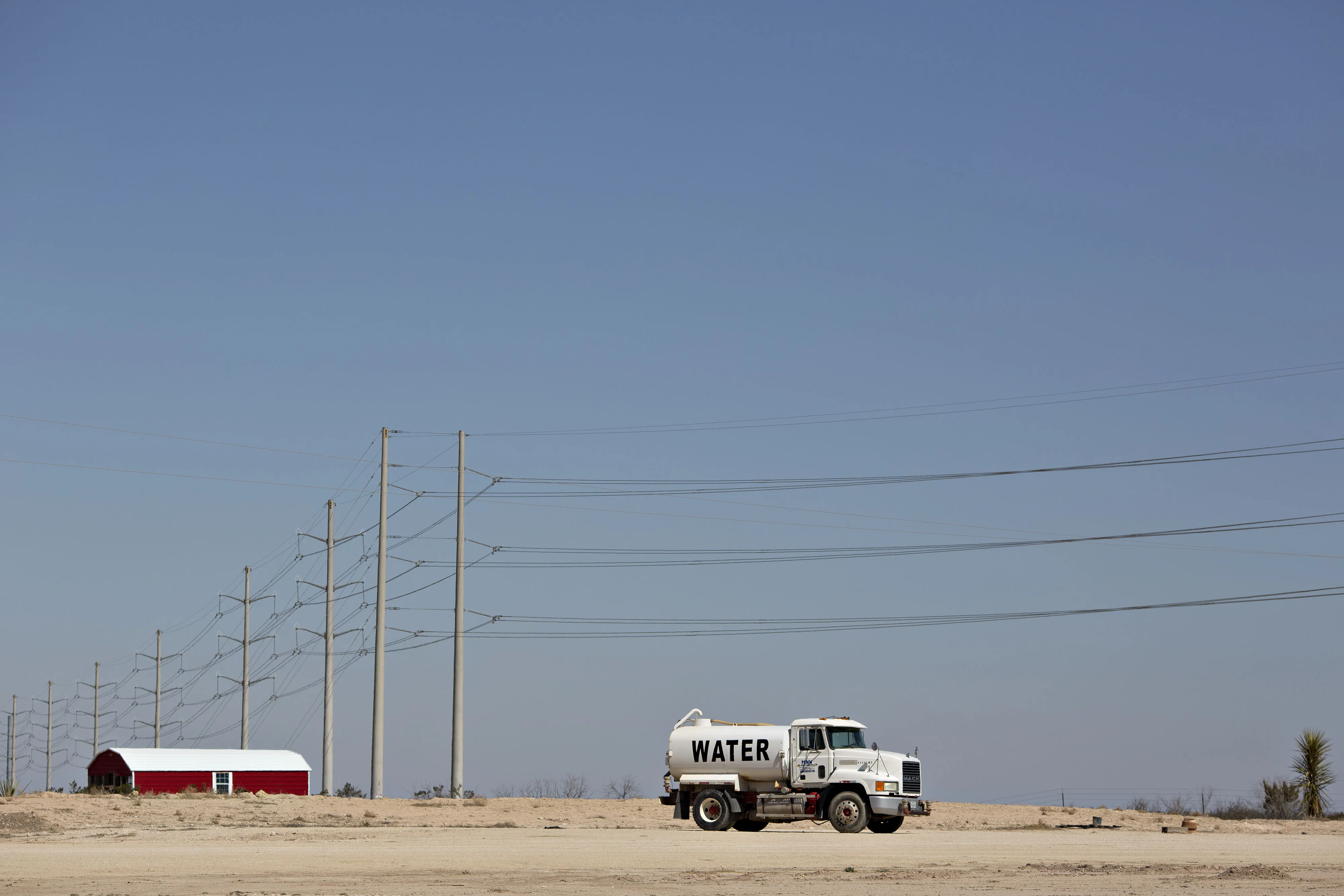 A water truck sits parked on a rural road in the Permian Basin outside Crane, Texas.