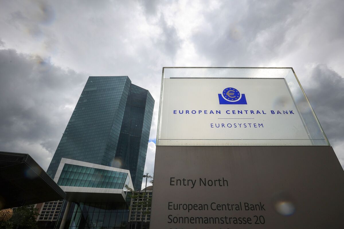 Entrada fechada de banco central europeu com moedas de euro na calçada.