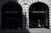 A pedestrian wearing a protective face mask walks past a Credit Suisse Group AG bank branch in Zurich, Switzerland, on Friday, April 17, 2020. Credit Suisse compensated managers and employees with additional shares in the bank after the price dropped sharply during the depths of a market correction spurred by the coronavirus outbreak.