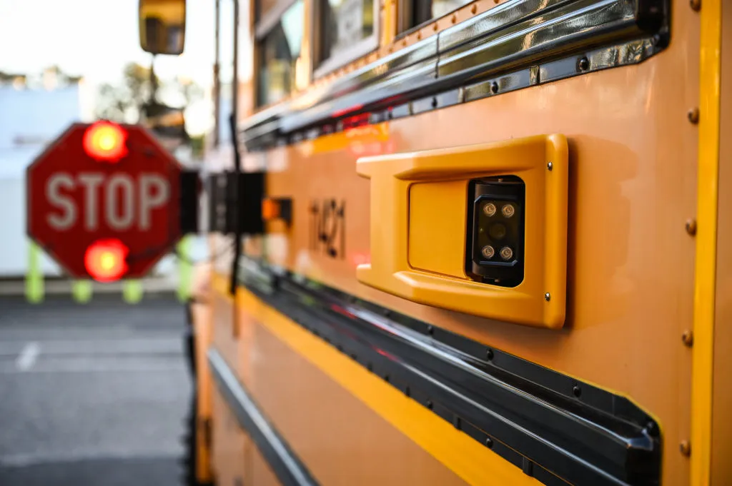 A camera attached to a school bus identifies cars that pass the bus stop arm.