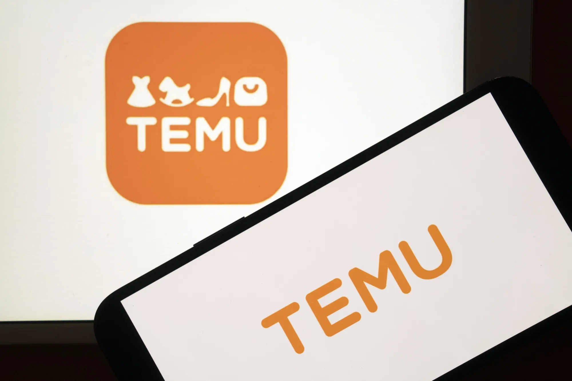 PDD Holdings Inc.'s Temu logo arranged on a smartphone and computer in Shanghai, China, on Monday, Feb. 3, 2025. President Donald Trump's new trade levies against China, Canada and Mexico include a broadside against e-commerce, with apparent plans to extinguish a long-held tariff exemption for packages worth less than $800.