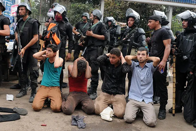 Egyptian security forces detain supporters of ousted Islamist President Mohammed Morsi as they clear a sit-in camp set up near Cairo University on August 14