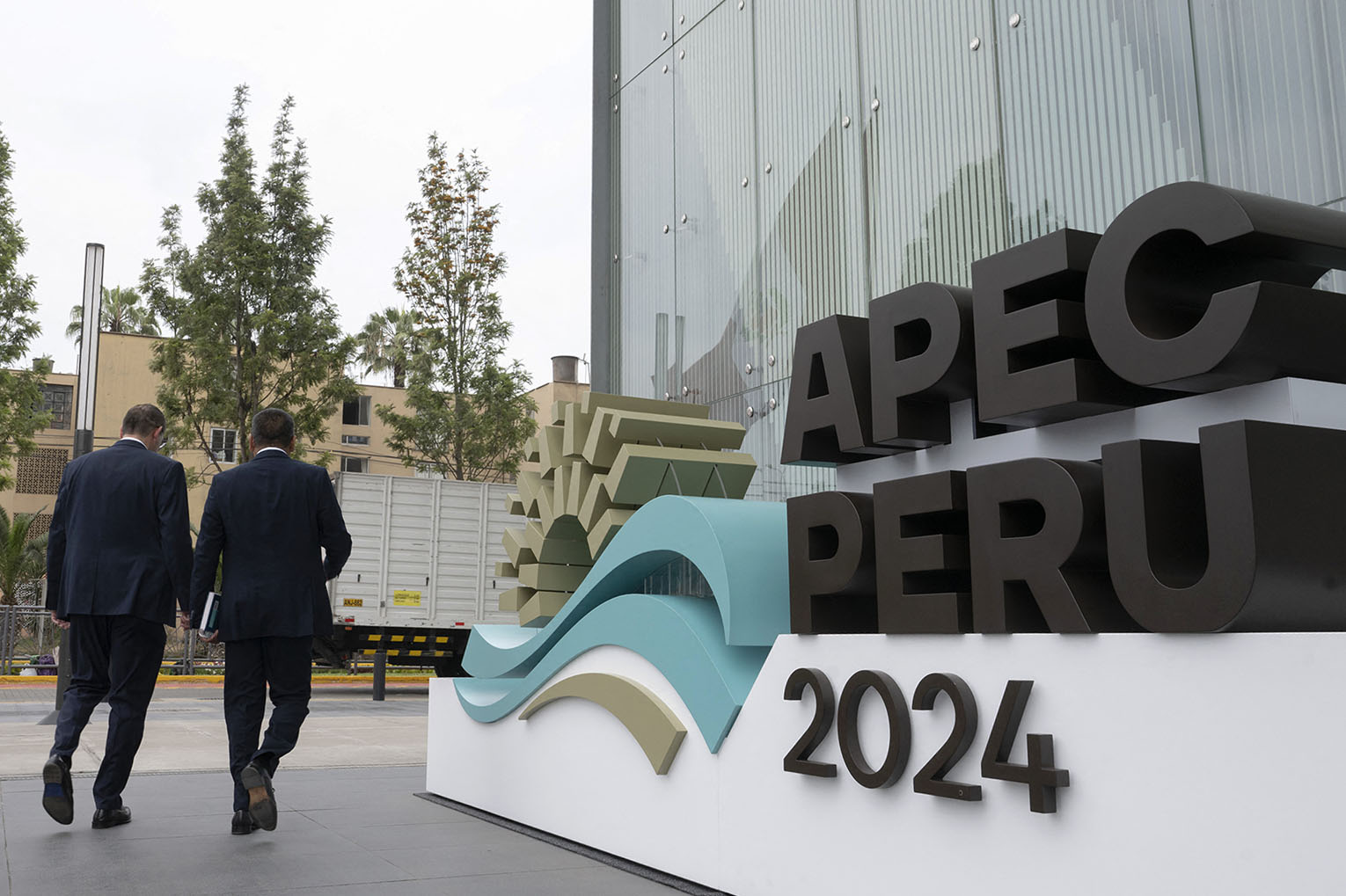 People walk by the entrance of the Lima Convention Center for the Asia-Pacific Economic Cooperation Summit in Lima, Peru, on Nov. 11.