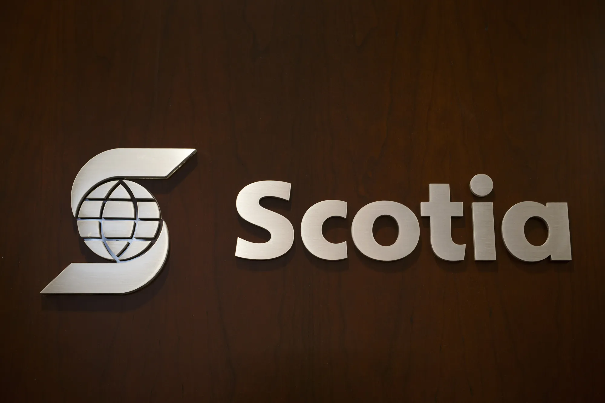 Bank of Nova Scotia signage is displayed outside Scotia Plaza in Toronto, Ontario, Canada. The bank&nbsp;will let go of 3% of its employees and take a writedown on an investment in a Chinese bank, leading to a C$590 million ($432 million) hit to earnings in the fourth quarter.&nbsp;