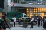 A logo for Shanghai Commercial Bank Ltd. is displayed atop the entrance to the Shanghai Commercial Bank Tower in the Central district of Hong Kong, China, on Tuesday, May 23, 2017. Soaring Hong Kong office rents, coupled with relentless pressure on hedge-fund fees industrywide, are prompting managers to choose between a fancy address and profits.
