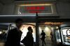 Pedestrians walk past illuminated signage for Daiwa Securities Co. displayed outside one of the company's branches at night in Tokyo, Japan.