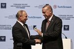 Recep Tayyip Erdogan, right, and Vladimir Putin shake hands in Istanbul on Nov. 19, 2019.