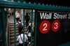 Commuters exit the Wall Street subway station near the New York Stock Exchange.