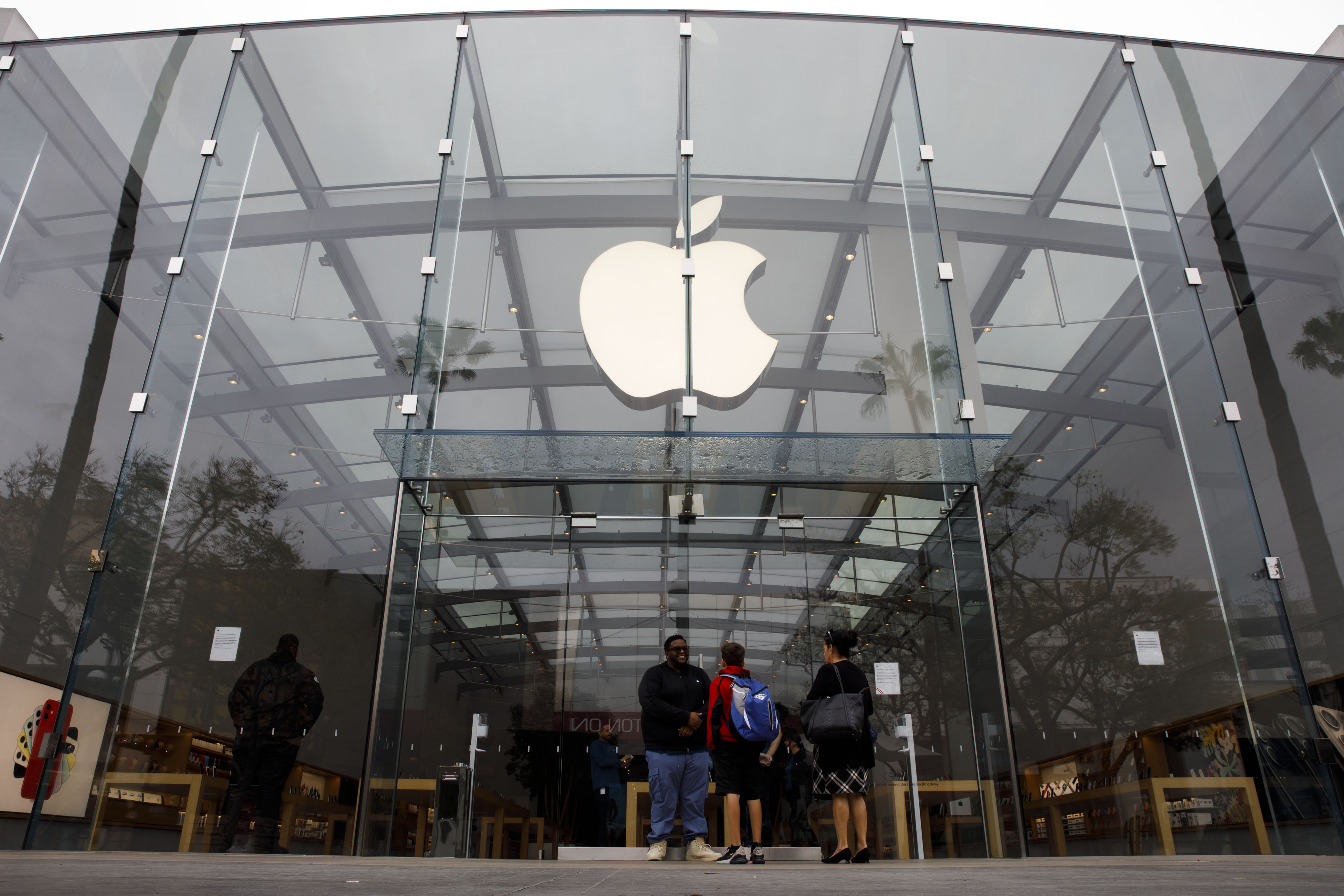 An Apple Inc. employee informs customers that the store is closed in Santa Monica, California, on March 14.