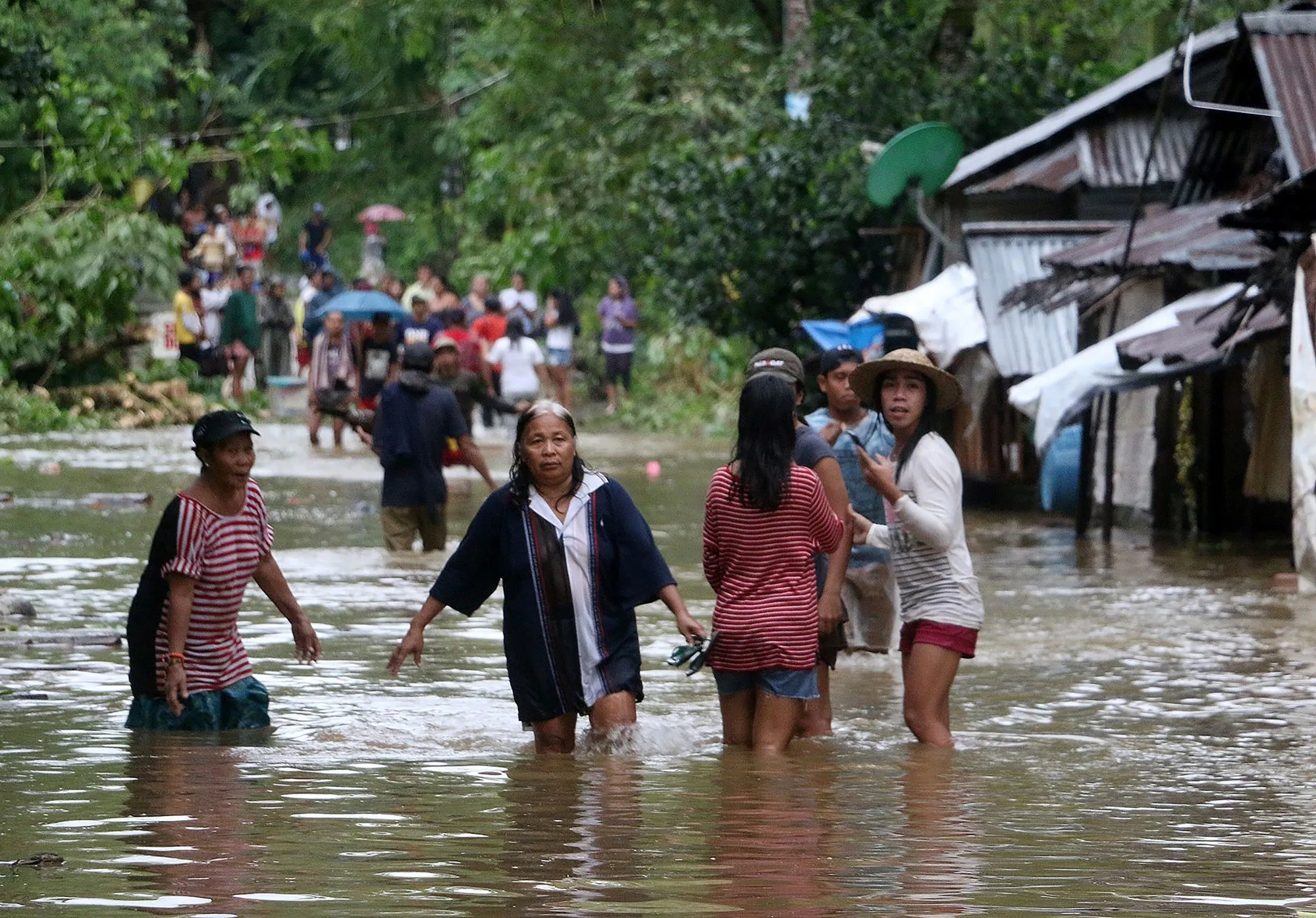 Villagers wade through a flooded street in Borongan, Philippines on Dec. 16.
