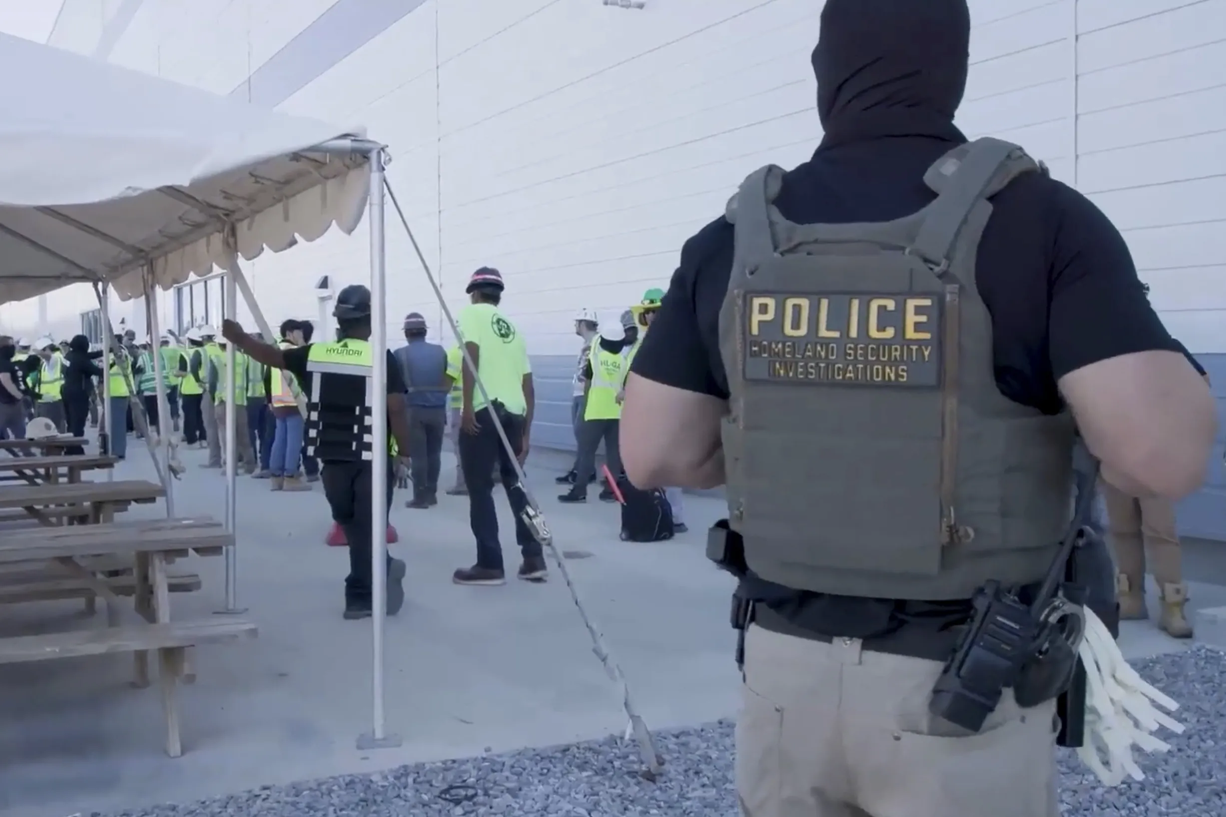 This image from video provided by U.S. Immigration and Customs Enforcement via DVIDS shows manufacturing plant employees being escorted outside the Hyundai Motor Group’s electric vehicle plant, Sept. 4.