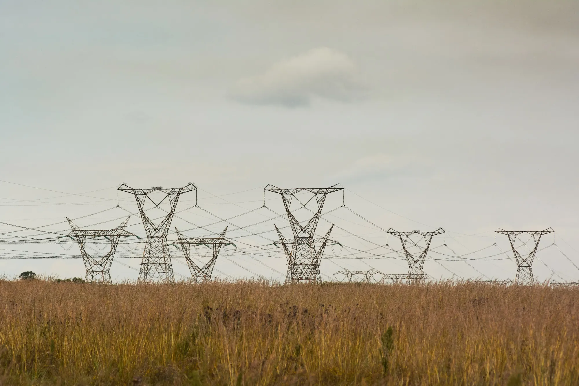 High voltage electricity transmission pylons close to the Eskom Holdings SOC Ltd. Matla coal-fired power station in Mpumalanga, South Africa.