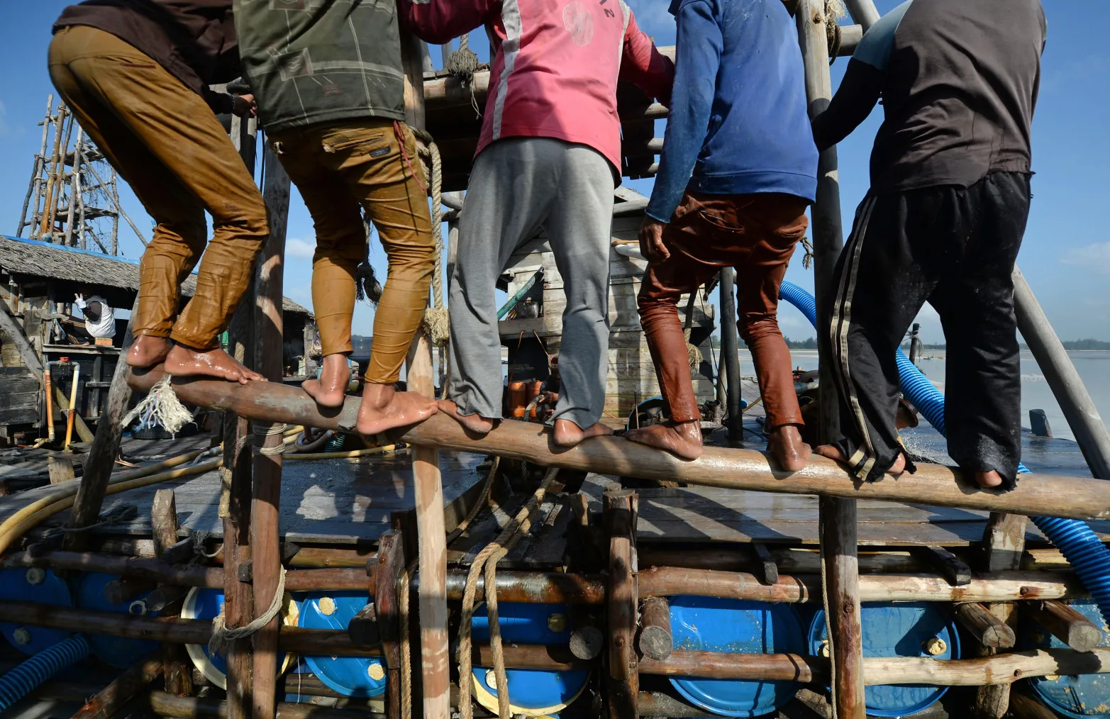 Workers operate a wooden raft to dredge for tin ore off the coast of Bangka Island, Indonesia, on Thursday, July 30, 2015. The islands of Bangka and Belitung produce more than 90 percent of the tin in Indonesia, which is the world's biggest exporter of the metal.
