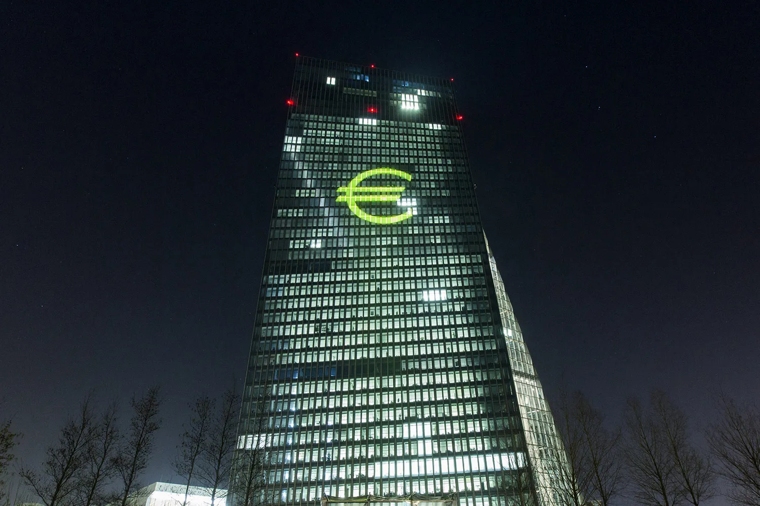 An illuminated euro currency symbol is projected on to the European Central Bank (ECB) headquarters during the Luminale light festival in Frankfurt, Germany.
